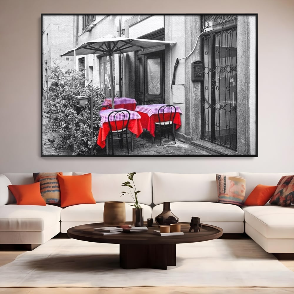 Tablou canvas cu cafenea stradala vintage alb negru cu pete de rosu, in rama de aluminiu negru, pe perete intr-un living